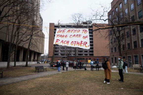 A sign hanging on a string that reads "we need to take care of each other.""